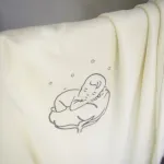 Couverture bébé bio écrue en double épaisseur avec le logo brodé gris
