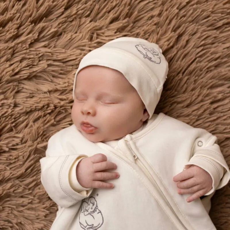 Bébé portant un bonnet naissance coton bio écru et un gilet écru