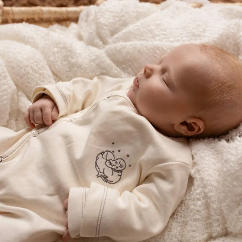 Nouveau-né endormi en grenouillère bébé bio écrue Bébé Coton
