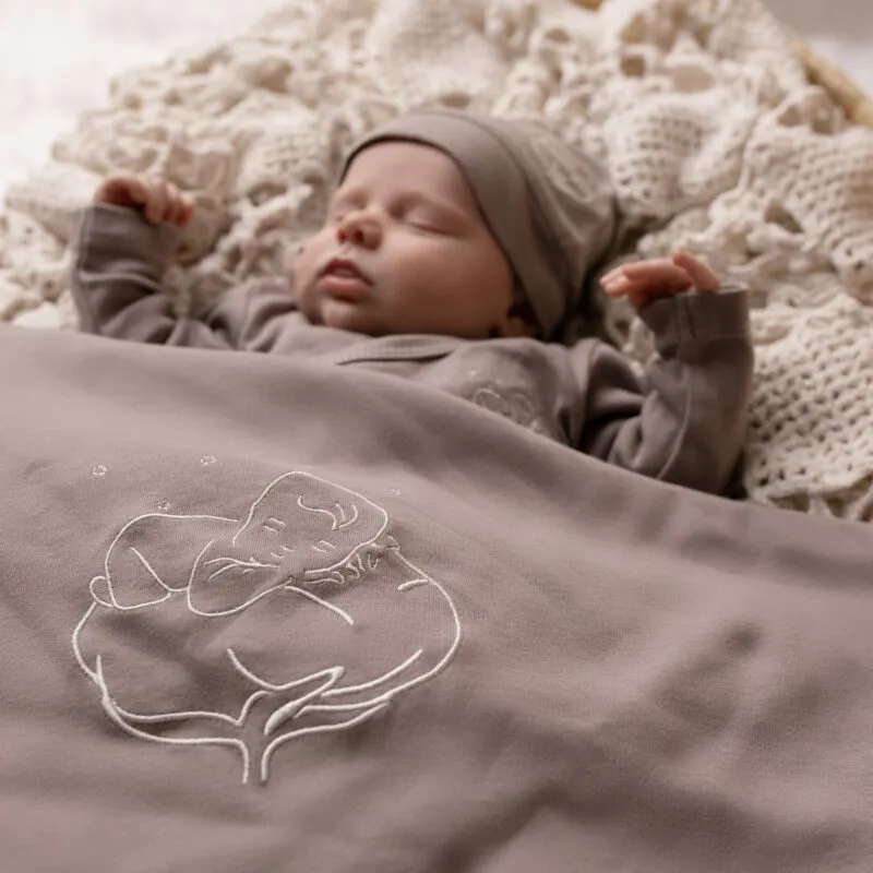 Nouveau-né endormi sous une couverture bébé bio gris violine Bébé Coton