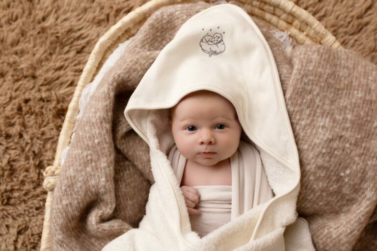 Paiement sécurisé Bébé Coton : bébé souriant dans une sortie de bain en coton bio